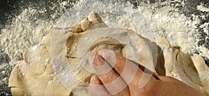 Hands knead the dough. The woman kneaded dough for baking or dumplings. Preparation of flour, water and egg mass for thermal