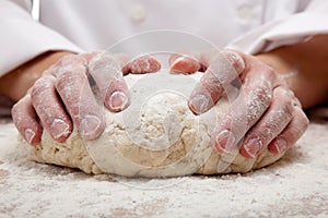 Hands kneading bread dough photo