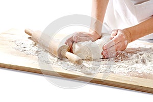 Hands kneading dough on board