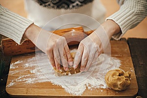 Hands kneading gingerbread dough on wooden board with rolling pin and flour. Making christmas gingerbread cookies. Woman preparing