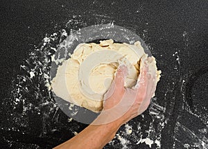 Hands kneading sticky dough
