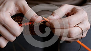 Hands with knitting needles in close up