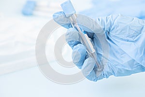 Hands of a lab technician with a tube of blood sample , lab assistant holds a blood test tube for research.