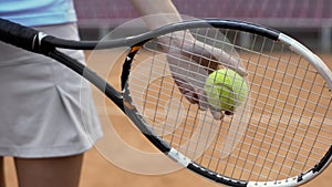 Hands of lady player holding racket and preparing to serve tennis ball, close up