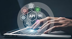 Hands on laptop with glowing API and technology icons application programming interface programming