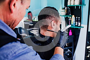 Hands of latin man stylist cutting hair to a client in a barber shop in Mexico photo