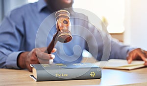 Hands, lawyer and gavel on books in office for attention, guide and justice in courtroom, law firm or truth. Closeup of