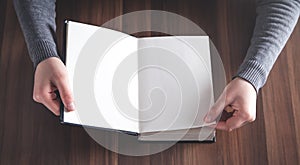 Hands leafing through book with blank pages