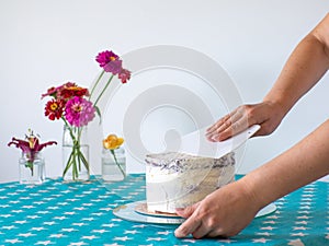 hands level the cream with a spatula and cover the round cake