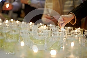 Hands lighting funeral candles