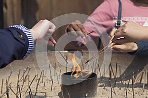 Hands lighting incense sticks at the temple of Todai-ji in nara in japan