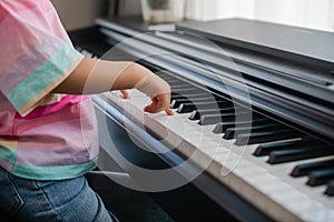 Hands of little girl playing piano, selective focus