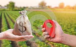 Hands with location pin and money bag. Buying and selling land. Land market. Estimation cost of plots. Legal regulation