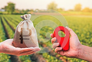 Hands with location pin and russian ruble money bag. Estimation cost of plots. Agriculture agribusiness. Transport and