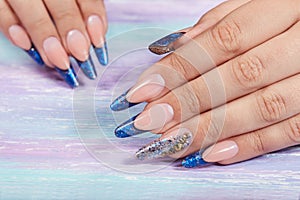 Hands with long artificial blue french manicured nails photo
