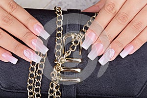 Hands with long artificial manicured nails with ombre gradient design