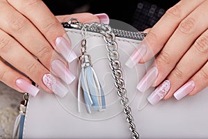 Hands with long artificial manicured nails with ombre gradient design