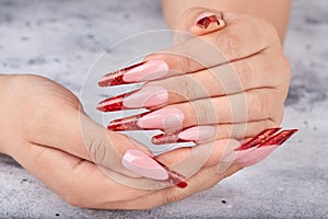 Hands with long red artificial french manicured nails