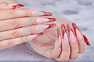 Hands with long red artificial french manicured nails photo