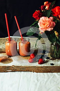 Hands makes strawberry smoothies in wooden table . Fresh strawbe