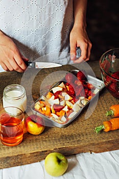 Hands makes strawberry smoothies in wooden table . Fresh strawbe