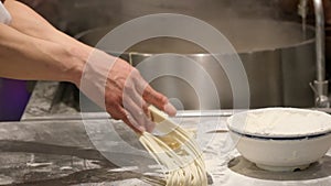 Hands making Chinese Lamian Noodles