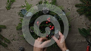 Hands making Christmas flower arrangement.