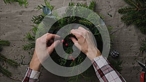 Hands making Christmas flower arrangement