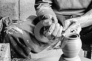 Hands of making clay pot on the pottery wheel ,select focus, close-up.