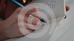 Hands making diary notes closeup. Happy smiling girl holding pen writing plans