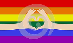 Hands making a heart on rainbow flag background. LGBT love support.