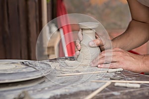 Hands making pottery