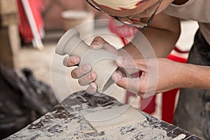 Hands making pottery