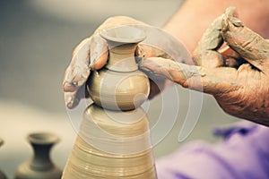 Hands making pottery on a wheel