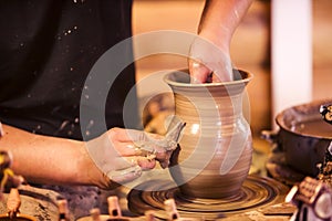 Hands making pottery on a wheel