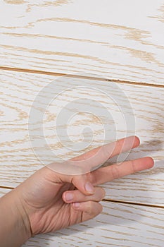 Hands making rock, paper, scissors gesture on wooden background