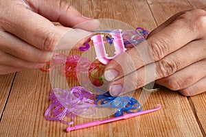 Hands making rubber band bracelet