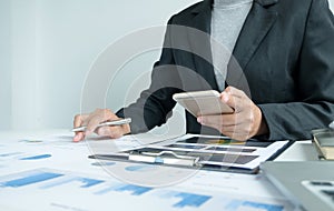 The hands of a male businesswoman are analyzing and calculating the annual income and expenses in a financial graph that shows