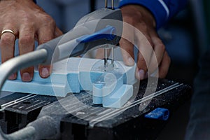 Hands of a male carpenter making a workpiece on a joiner`s machine