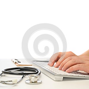 Hands of a male doctor who uses a computer keyboard