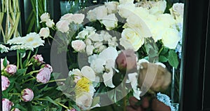 Hands of a male florist choosing flowers for a bouquet