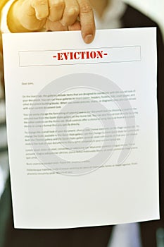 Hands of a Male Landlord Holds an Eviction Notice - Loss of Home - Own - Rent - Bad Economy