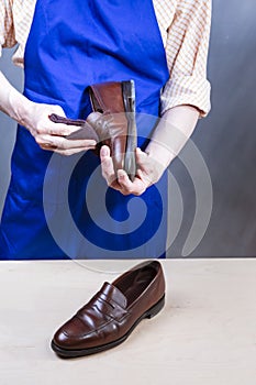 Hands of Male Shoes Cleaner with Cloth For Brown Leather Penny Loafers Footwear While Cleaning in Workshop