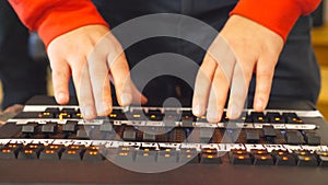 Hands of male sound engineer presses the keys and moves buttons of soundboard . Arms of man working on professional