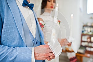 Hands of man with candle at church on wedding