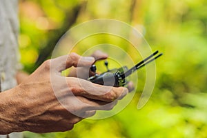 Hands of a man with a control panel for drones