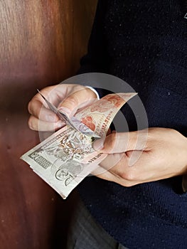 hands of a man counting honduran banknotes