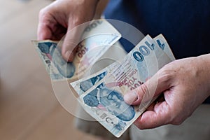 Hands of man counting Turkish Lira