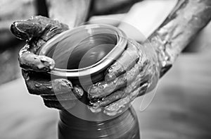 Hands of a man creating pottery on wheel