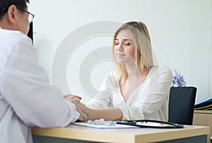 Hands man doctor reassuring to happy female patient and giving a consultation and encouragement at hospital